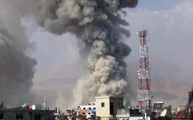 Buildings on fire in Douma after shelling by loyalists. Photo: AFP