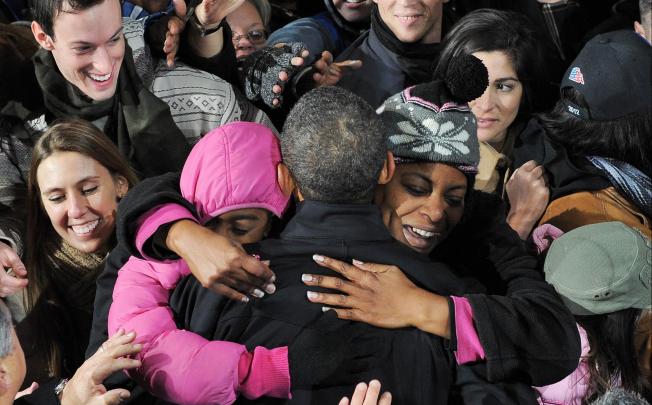 Barack Obama is enveloped in bear hugs during a campaign rally in Bristow, Virginia, during a gruelling final weekend of campaigning before handing his fate over to voters. Photo: AFP