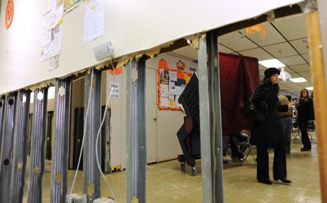 A woman leaves an election booth in Hoboken, where ballots were cast amid hurricane debris. Photo: EPA