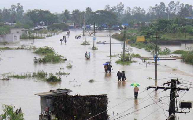 Indian residents wade through flood waters in Visakhapatnam in the coastal district of Andhra Pradesh on Monday. Photo: AFP