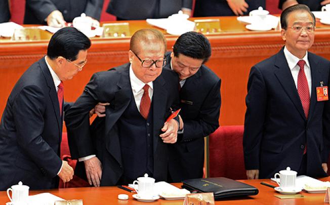 Hu Jintao (left) helps former leader Jiang Zemin stand. Photo: AFP