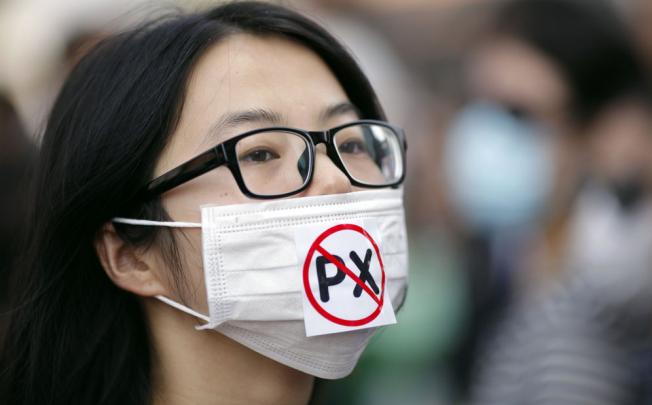 A protester wears a mask with a reference to the dangerous chemical paraxylene that the Ningbo plant already produces. Photo: Reuters  