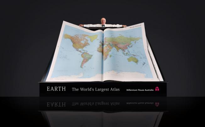 Gordon Cheers, managing director of Millennium House, with one of only 31 copies of the 150kg world atlas, Earth Platinum. Photo: Millennium House