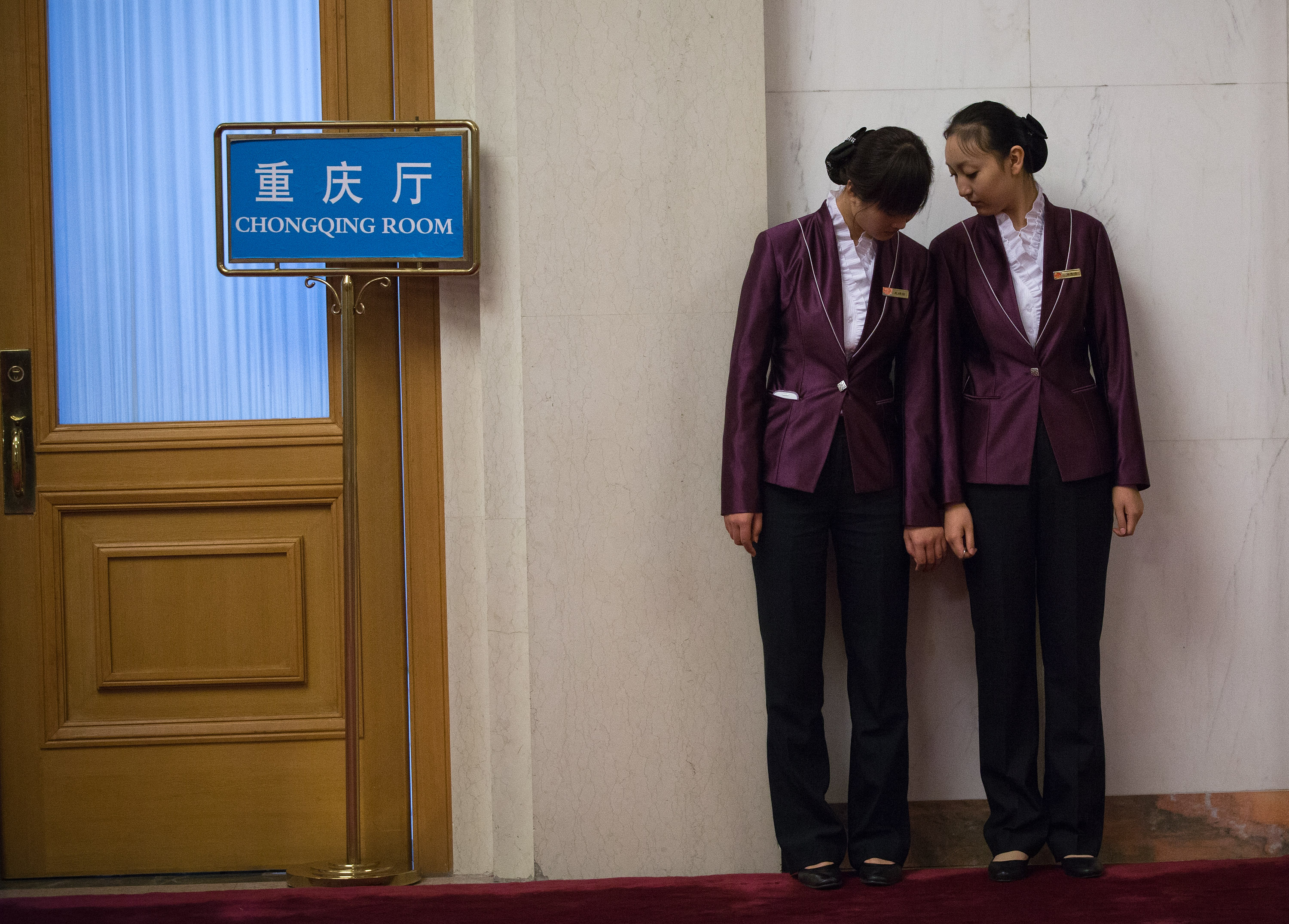 Two service staff stand outside the Chongqing room at the Great Hall of the People in Beijing during the 18th Communist Party Congress on Nov. 8, 2012. Photo: AP