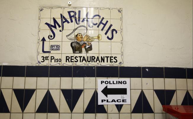 A directional sign points the way to a polling place inside El Mercado de Los Angeles, a Mexico-style marketplace in the heavily Latino East L.A. area, during the U.S. presidential elections. Photo: AFP