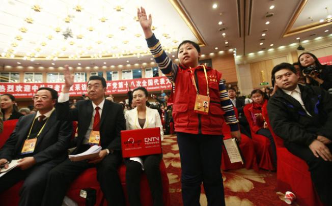 Eleven-year-old Zhang Jiahe raises his hand during a press conference on the sidelines of the 18th Communist Party Congress in Beijing on Monday. Photo: EPA