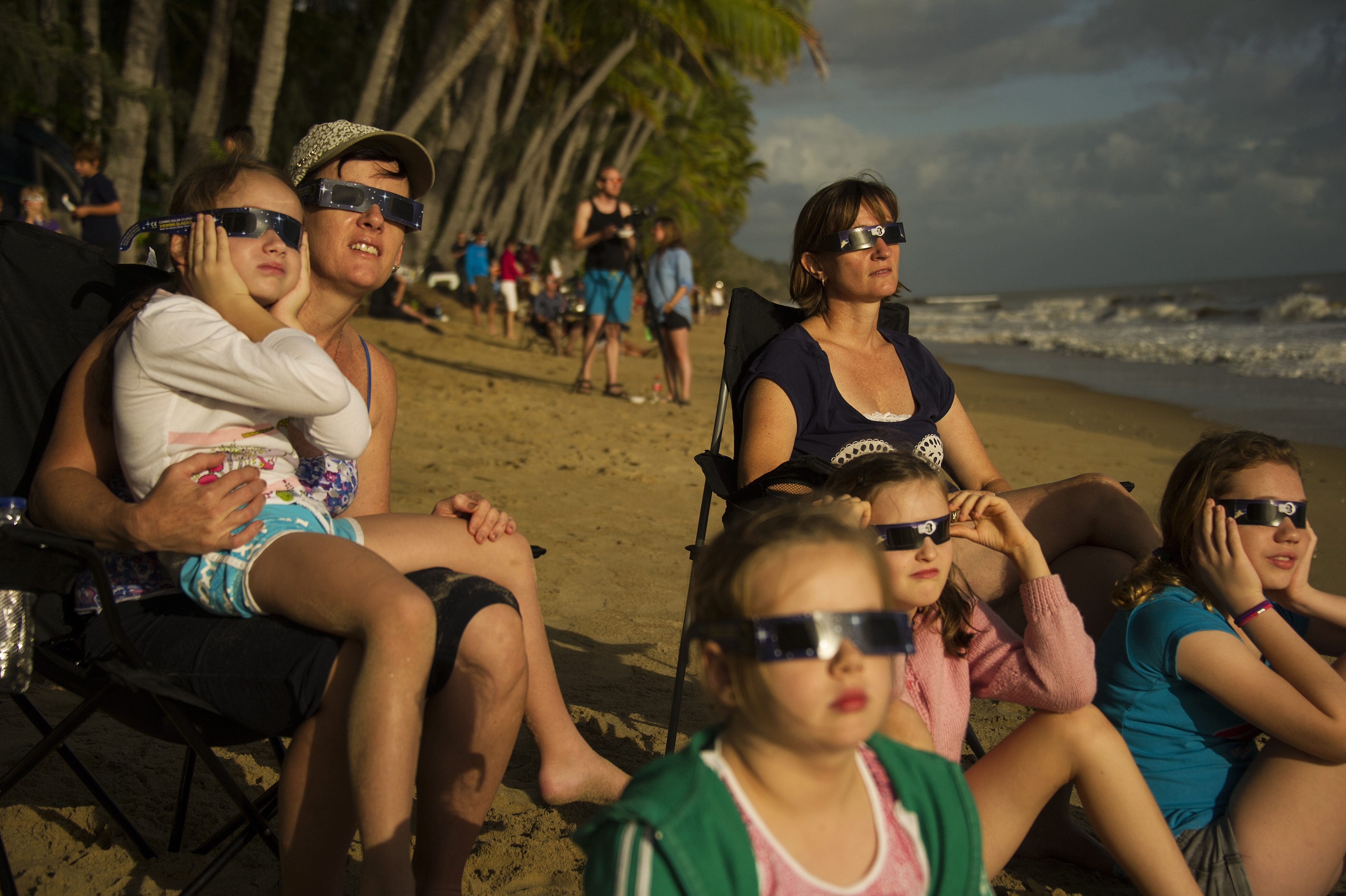Families watch a total solar eclipse from Ellis Beach, north of Cairns in far north Queensland, Australia, on Wednesday. Photo: EPA