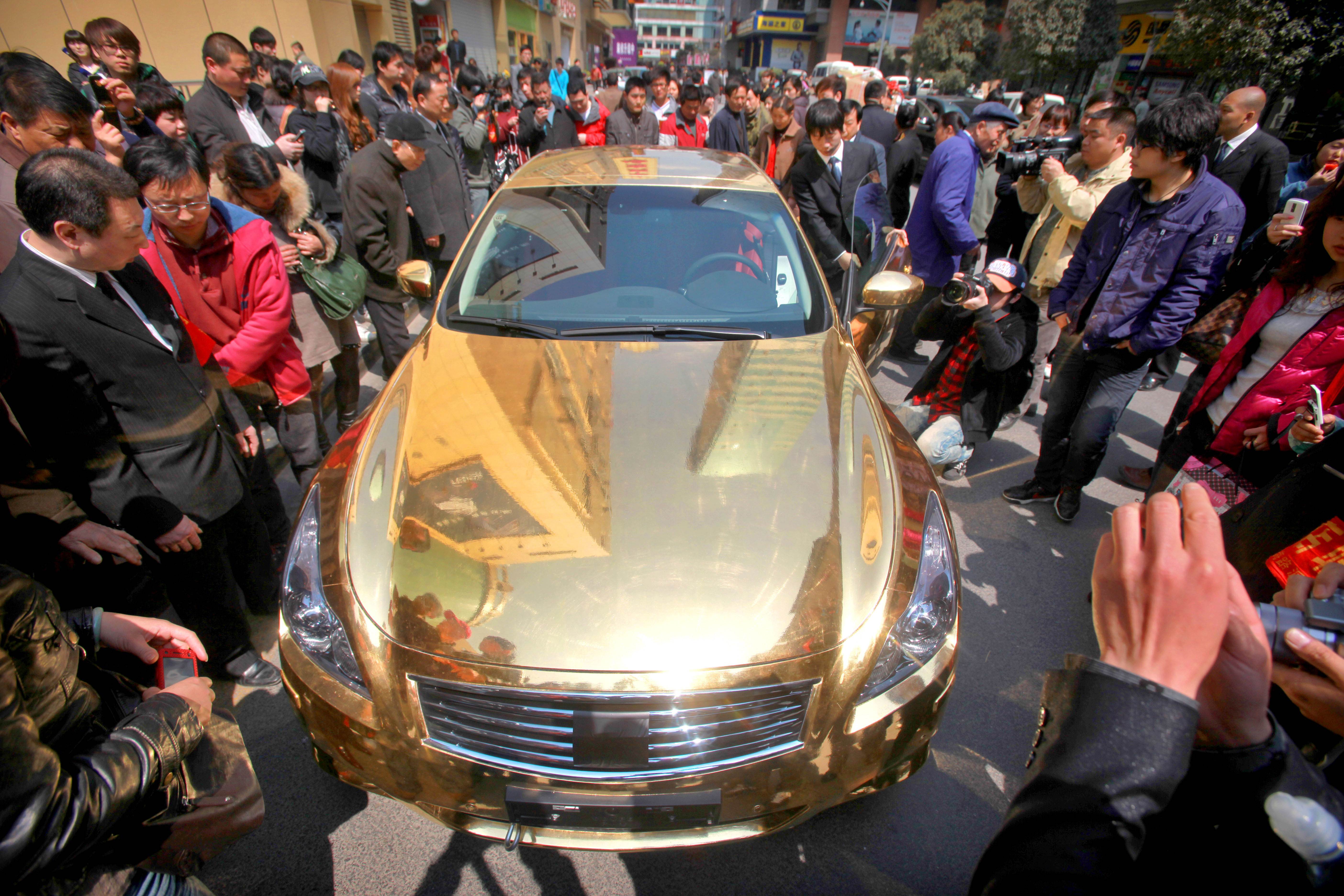 A gold-plated luxury sports car sums up the lifestyle of the super rich in China. Many mainlanders are now looking to invest more of their assets overseas. Photo: AFP