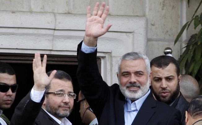 Senior Hamas leader Ismail Haniyeh (right) and Egyptian Prime Minister Hesham Qandil wave as they meet in Gaza City. Photo: AP
