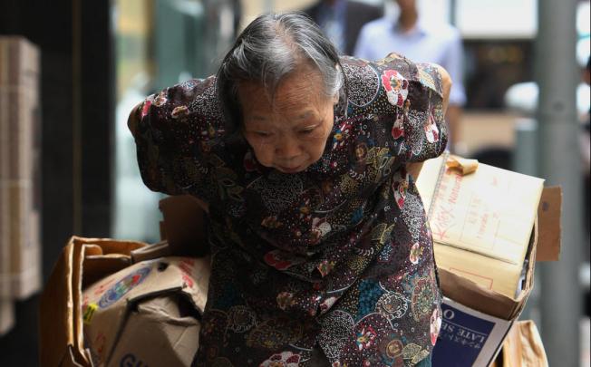 An elderly woman collecting cardboard. Photo: David Wong