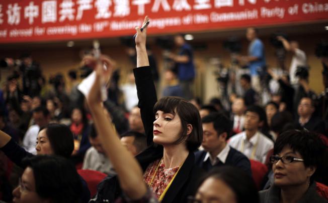 A foreign journalist raises her hand to ask a question during a news conference at the 18th National Party Congress. Photo: Reuters