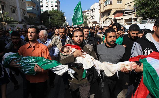 Palestinian mourners carry the bodies of members of the al-Dallu family during their funeral procession in Gaza City on Monday. Photo: AFP