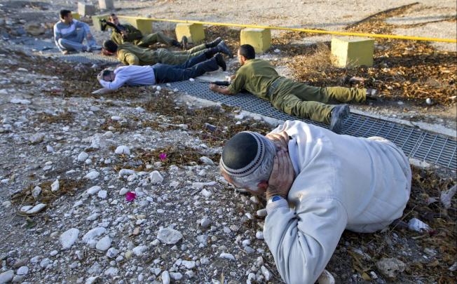 An Israeli man drops to the ground after hearing a Palestinian rocket siren. Photo: EPA