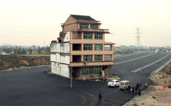 Luo Baogen, 67, and his wife, 65 own the house  in the middle of a huge dual carriageway in Wenling. Photo: AFP