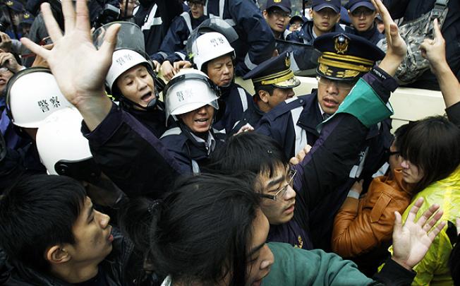 Demonstrators scuffle with police during a protest against the sale of influential media outlets to a pro-China businessman in Taipei on Tuesday. Photo: AP