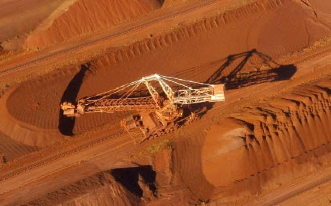 A bucket wheel reclaimer collects ore at the BHP Billiton iron ore loading facility in Perth, Australia. Photo: Reuters