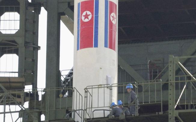 Engineers check the top of a rocket sitting on a launch pad at the West Sea Satellite Launch Site, northwest of Pyongyang, in April. Photo: Reuters