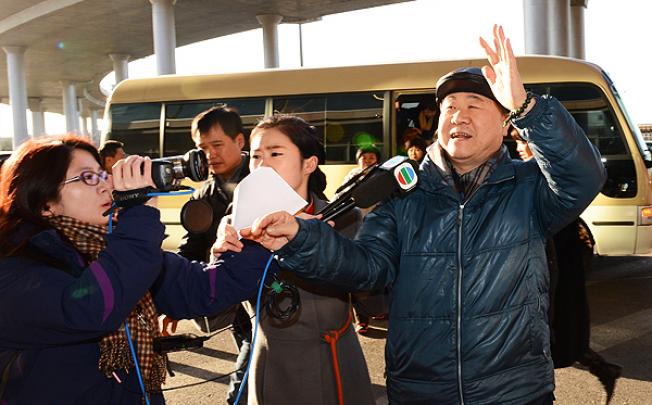 Nobel Prize for Literature winner, Mo Yan, talks to journalist outside Beijing airport before leaving for Sweden to accept the award. Photo: Xinhua