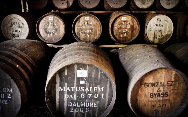 Barrels at The Dalmore distillery in Scotland (above) and its master distiller Richard Paterson (below right).