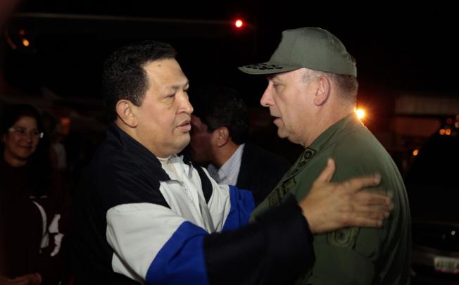 Venezualan President Hugo Chavez (left) speaks with his ministers at Simon Bolivar international airport after a trip to Cuba on Friday. Photo: AFP