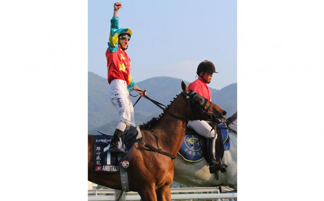 An overjoyed Zac Purton stands in the stirrups of superstar Ambitious Dragon after his victory in the Hong Kong Mile.