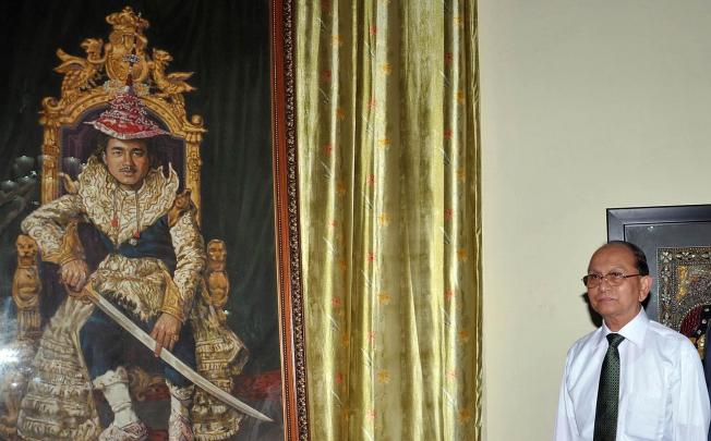 Thein Sein stands next to a photograph of King Thibaw. Photo: AFP