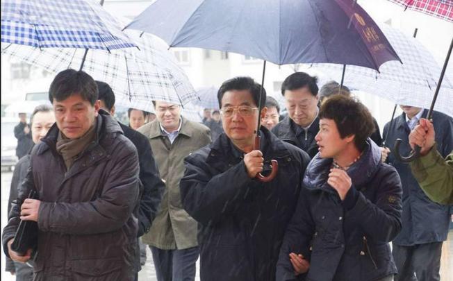Hu Jintao holds an umbrella for a village official while visiting Yancheng, Jiangsu. Photo: SCMP