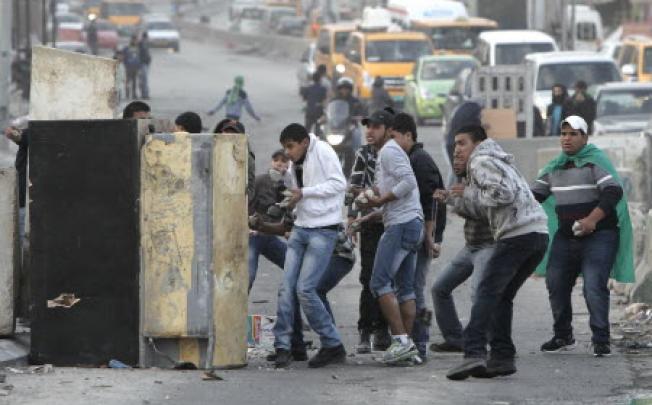 Palestinian youth clash with Israeli soldiers in the occupied territories late last year. On Monday, Israel dropped its five-year ban on construction materials crossing into the territory. Photo: Reuters