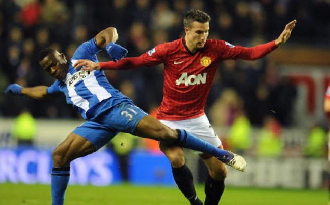 Manchester United's Robin Van Persie (right) vies for the ball with Wigan's Maynor Figueroa (left) during English Premier League soccer match Wigan vs Manchester United at DW Stadium, Wigan. Photo: EPA