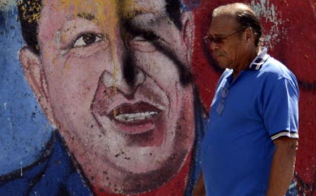  A man walks past a mural of Venezuelan President Hugo Chavez in Caracas. Chavez on Wednesday was said to be in “stable”, but still delicate condition. Photo: AP
