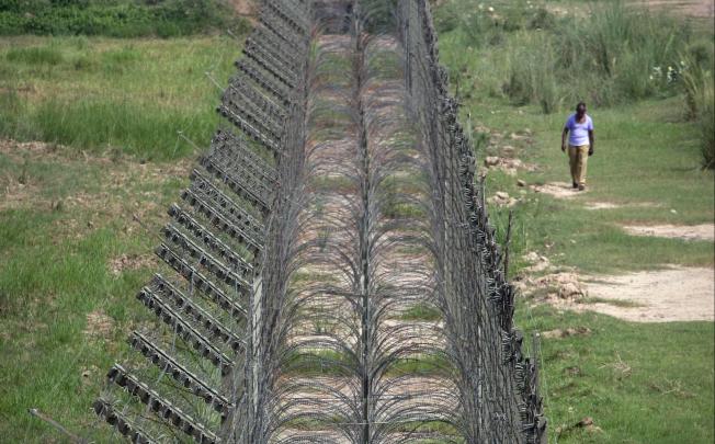 An Indian Border Security Force (BSF) trooper walks near the fenced border with Pakistan in Suchetgarh, southwest of Jammu. Photo: Reuters