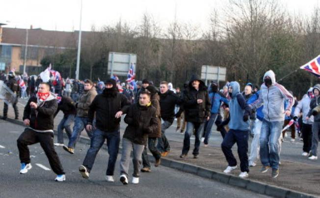 Loyalists react after being attacked by Nationalists throwing stones from the Nationalist Short Strand area of Belfast in Northern Ireland. Photo: EPA