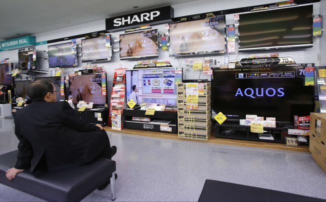 A shopper looks at Sharp LCD screens in a Tokyo shop. Sharp is in talks with Lenovo about selling an LCD TV plant in Nanking and tying up with the Chinese computer company. Photo: Reuters