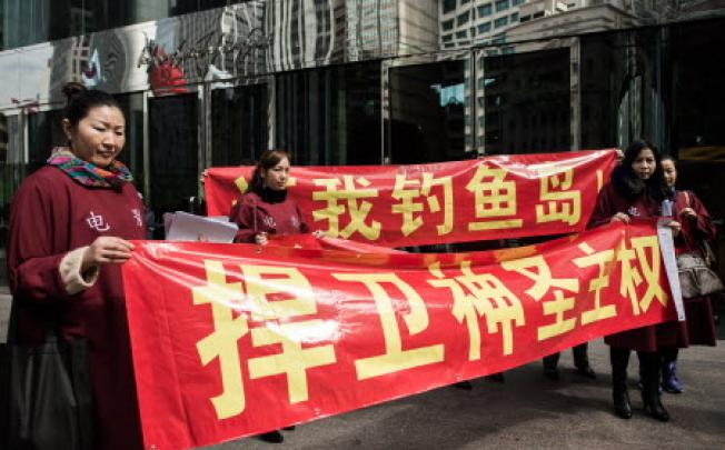 Hong Kong activists display anti-Japan banners in front of the building housing the Japanese consulate in Hong Kong on January 8, 2013.  Photo: AFP 