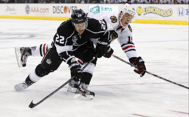 Los Angeles Kings' Trevor Lewis (left) and Chicago Blackhawks' Jonathan Toews reach for the puck. Photo: AP