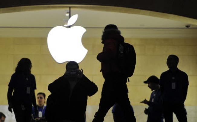 People walk past the Apple logo at the Apple Store at Grand Central Terminal in New York. Photo: AFP