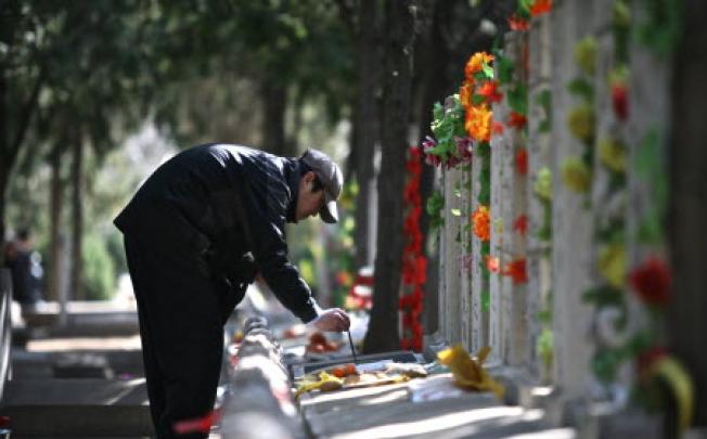 A Chinese man tends to a grave of a family member at a cemetary in Beijing. Photo: AFP