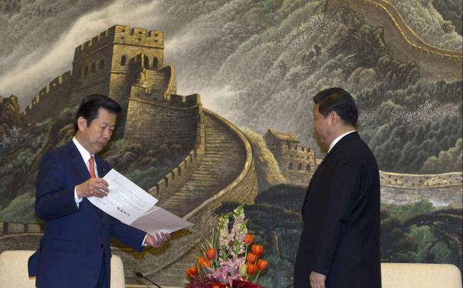 Yamaguchi, leader of Japan's New Komeito party, prepares to deliver a personal letter from Japan's Prime Minister Abe to China's president-in-waiting Xi during a meeting at the Great Hall of the People in Beijing. Photo: Reuters