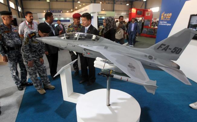 Military officials looking at a model of a FA-50 fighter jet. Manila will soon finalise a US$443 million deal to buy 12 of the jets. Photo: AFP