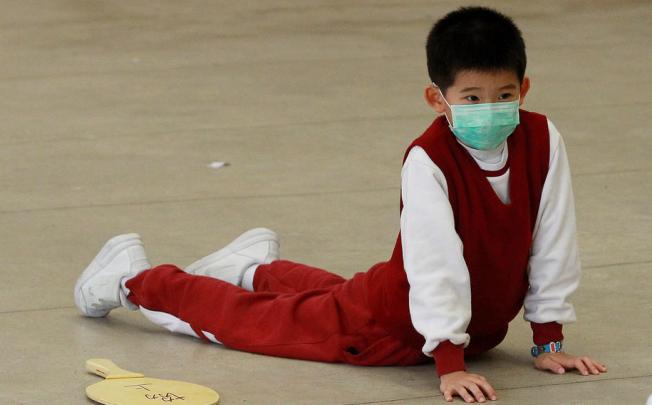 A local student wears a mask as he attends a PE lesson on a hazy day. Photo: K. Y. Cheng