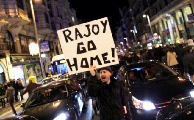 Protestors shout slogans and wave banners placards reading "Rajoy go home" during a demonstration against corruption in Madrid, on Saturday. Photo: AP