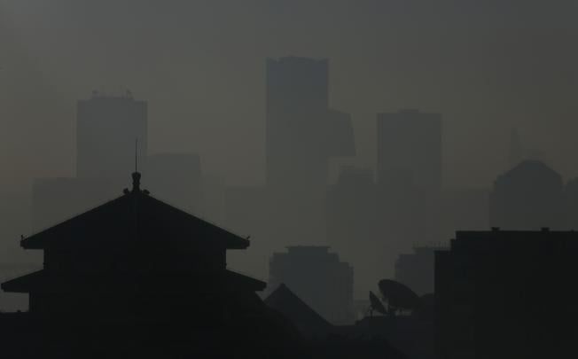 The silhouettes of buildings are seen through haze in Beijing. Photo: Reuters