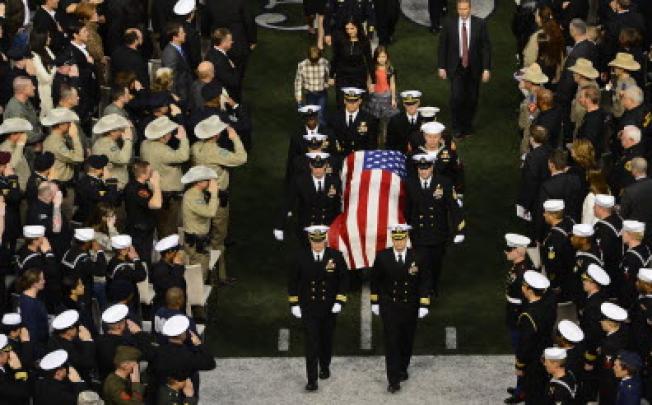 Taya Kyle and her son and daughter exit the memorial behind husband Chris Kyle's coffin after a service for the Navy Seal sniper at Arlington in Texas. Photo: EPA 