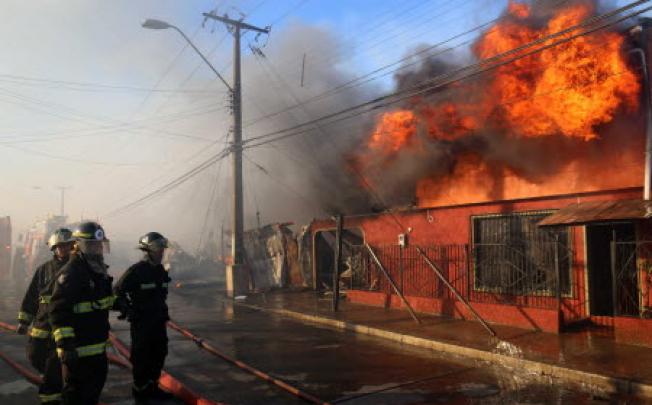 Firefighters try to extinguish a fire in Valparaiso in Chile. Photo: EPA