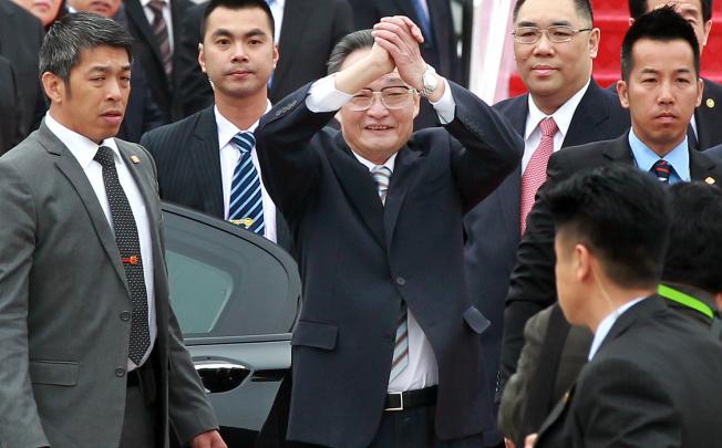 Wu Bangguo (centre) arrives in the city, flanked by Macau Chief Executive Fernando Chui Sai-on (in red tie). Photo: SCMP 