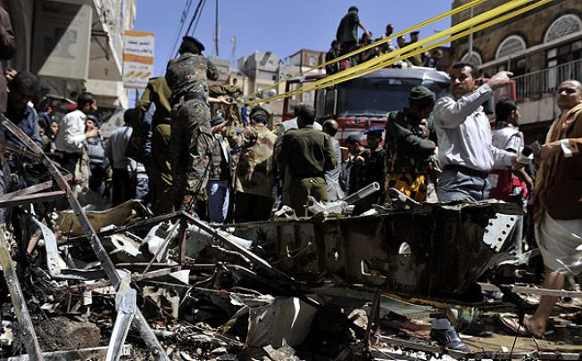 Policemen collect wreckage of the crashed plane in Sanaa, Yemen. Photo: Xinhua