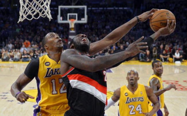 Los Angeles Lakers centre Dwight Howard, left, blocks the shot of Portland Trail Blazers centre J.J. Hickson as guard Kobe Bryant (second from right) and forward Earl Clark (right) look on. Photo: AP