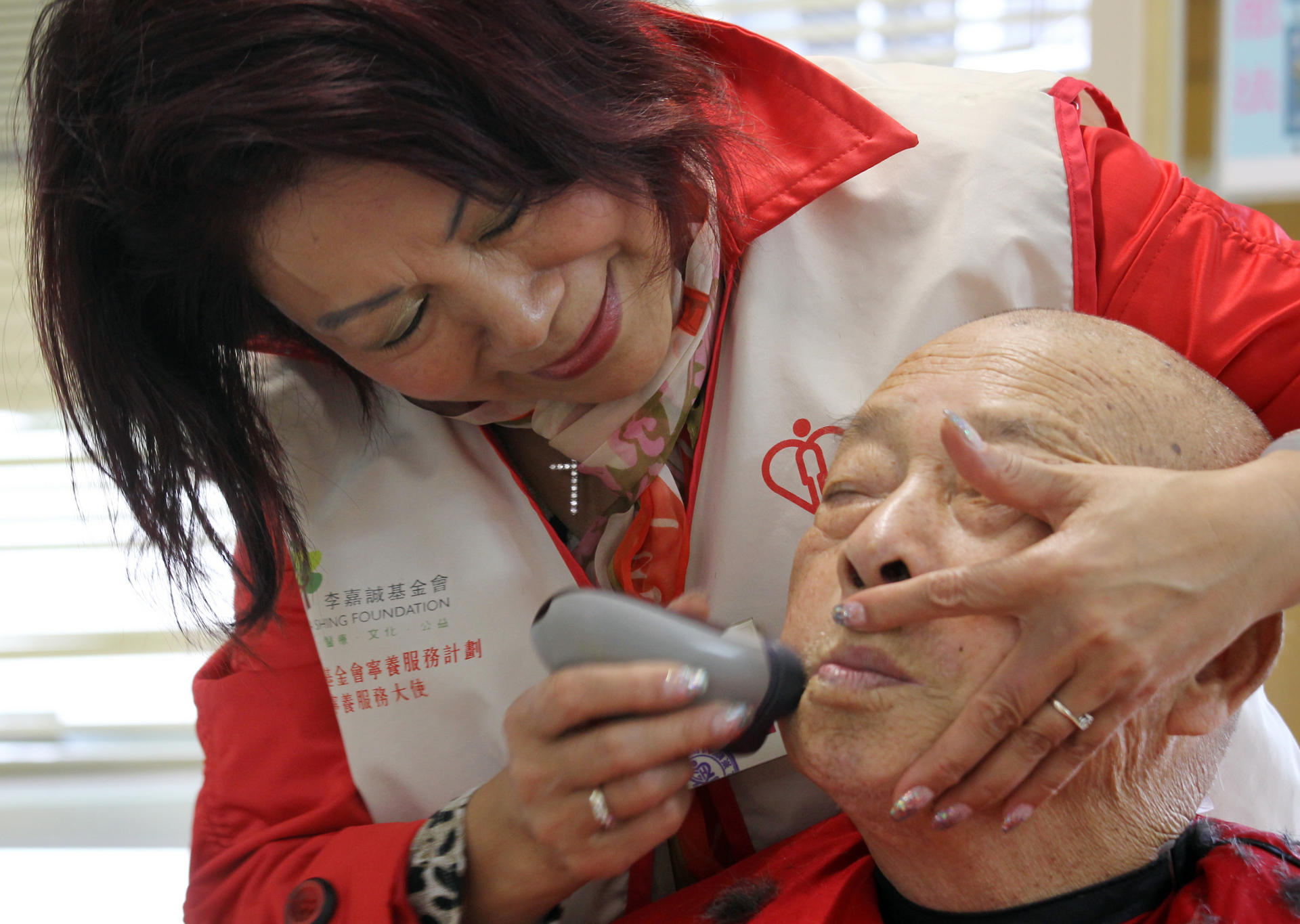 Because they're worth it: Beauty parlour owner Jenny Law, 62, gives Lam Choi-shing, 78, a close shave at Grantham Hospital. Photo: Dickson Lee