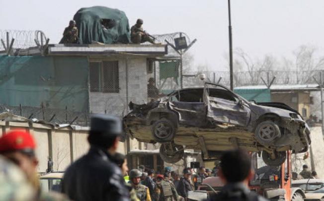 Afghan security officials inspect the scene of a suicide bomb attack outside the Afghan Defence Ministry in Kabul on Saturday. Photo: AFP