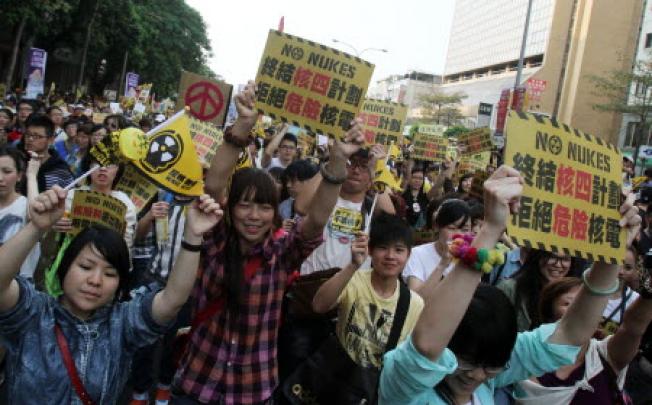 Taiwanese hold a slogan reading "Stop Nuclear Power Plant 4. Reject Dangerous Nukes" during a demonstration in Taipei on Saturday. Photo: AP